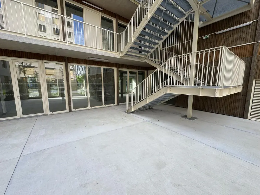 Escalier métallique extérieur desservant les niveaux depuis la cour